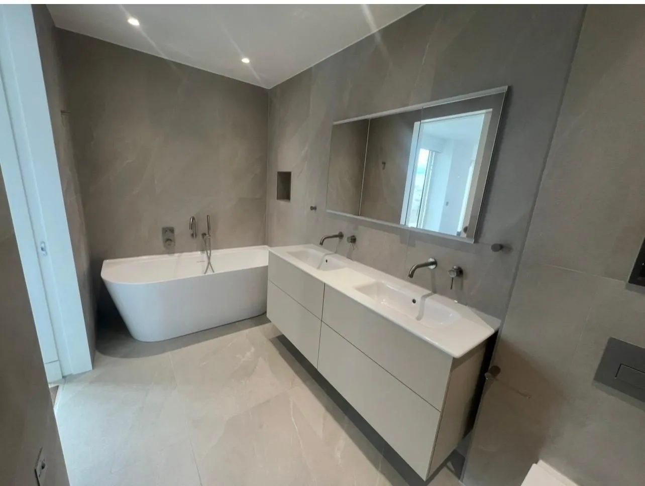 Grey stone-effect porcelain bathroom with a freestanding bath and double vanity