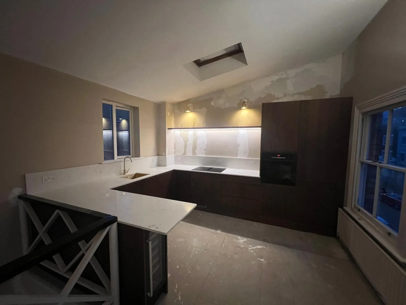 Kitchen with dark units, quartz worktops and a tiled floor