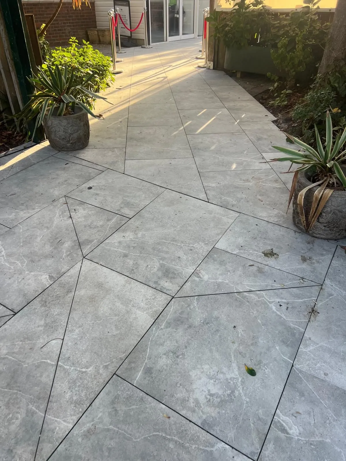 Outdoor porcelain laid with angled cuts around planters