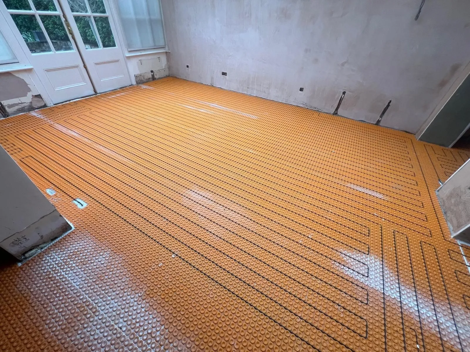 Underfloor heating laid across a large open-plan floor before tiling